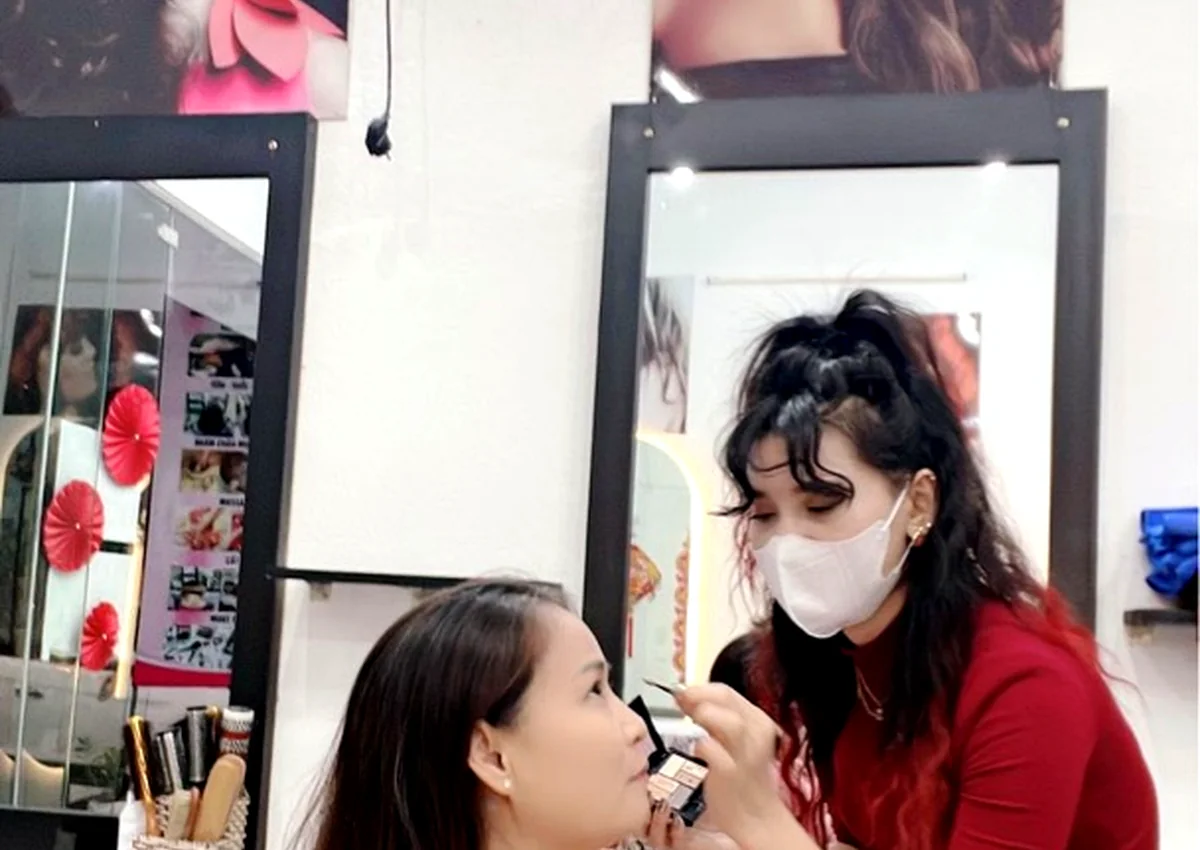 Chủ salon đang làm tóc cho khách hàng